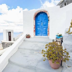 Stairs leading to doorway in Greece with ocean in background